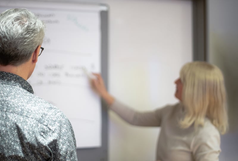 Bufab-two-colleagues-writing-on-whiteboard