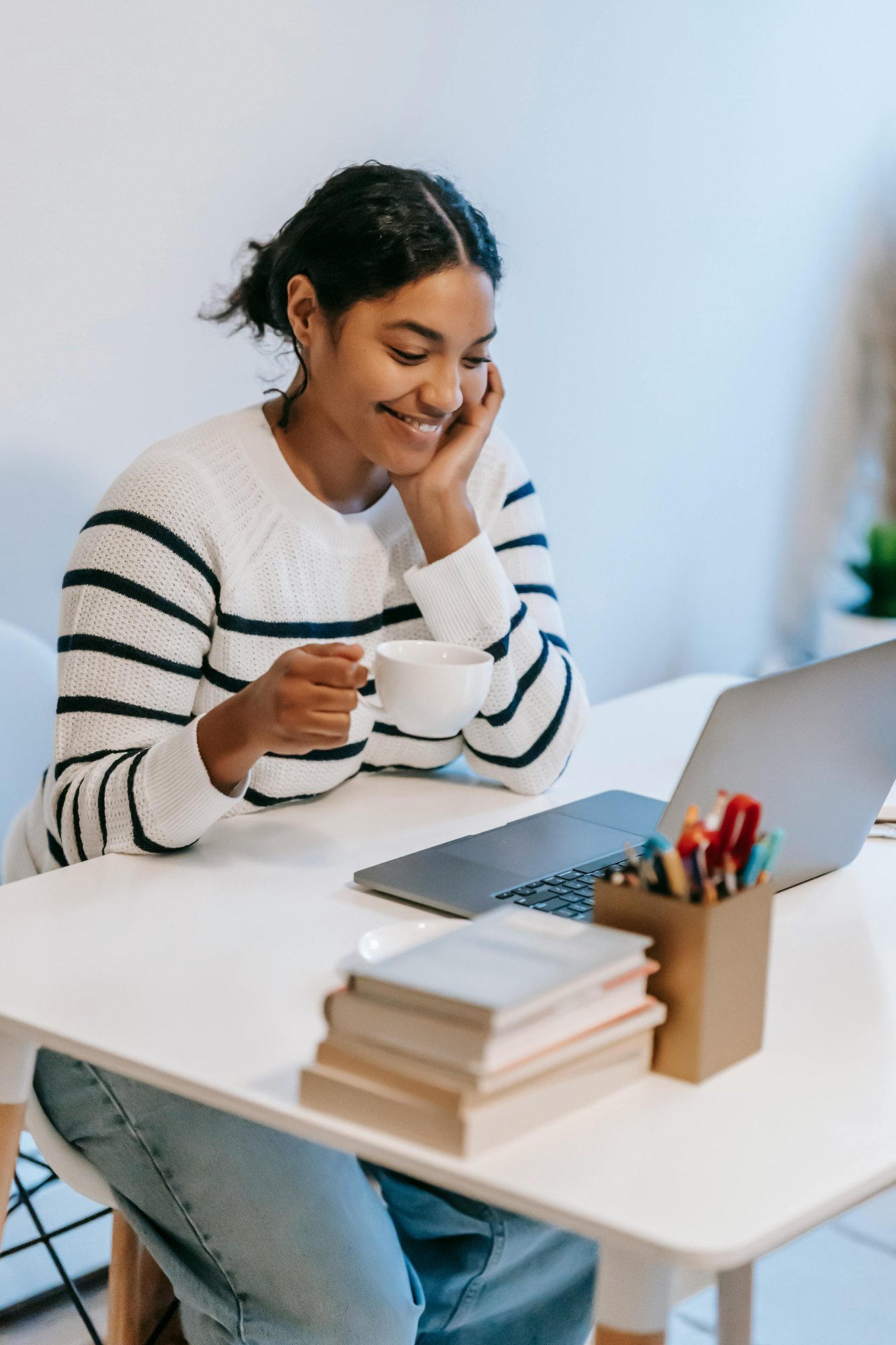 Woman drinking coffee and looking at her computer